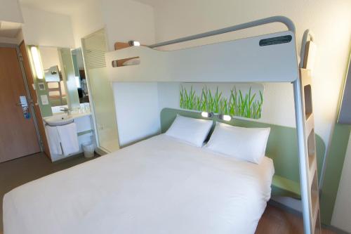 a bedroom with a bunk bed with white pillows at ibis budget Cherbourg - La Glacerie in Cherbourg en Cotentin