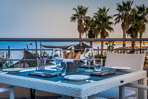 a table on a balcony with a view of the beach at Aregai Marina Hotel & Residence in Santo Stefano al Mare