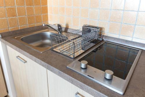 eine Küchenspüle mit einem Wäscheständer und 2 Tassen in der Unterkunft MSE Apartman in Miskolc