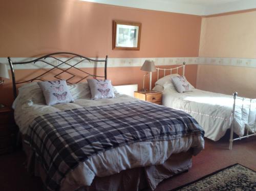 two beds in a bedroom with pink walls at Westcourt Farm in Shorwell