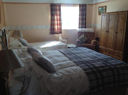 1 dormitorio con 1 cama, 1 silla y 1 ventana en Westcourt Farm, en Shorwell