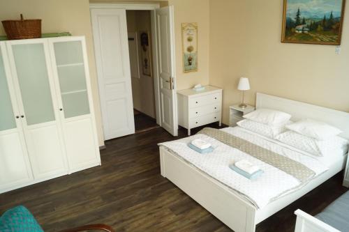 a bedroom with a white bed and a white cabinet at Apartmány Mary in Litoměřice