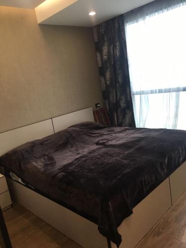 a bed in a room with a window at Premium apartment in Porta Batumi Tower in Batumi