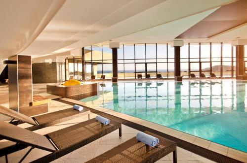 a large swimming pool with chairs in a building at Hotel Croatia in Cavtat