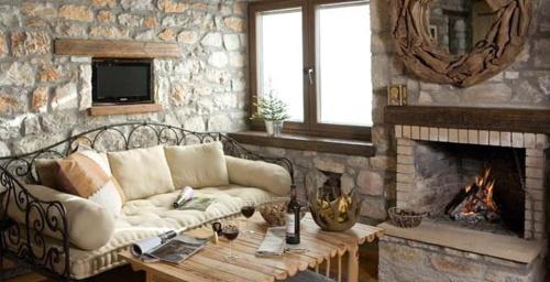 a living room with a couch and a fireplace at Μαγεμένο Βουνό in Karpenision