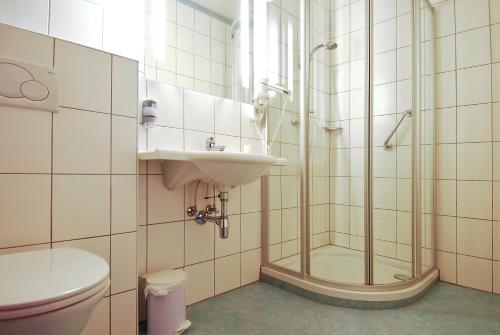 uma casa de banho com um chuveiro, um lavatório e um WC. em Gasthof Weißes Rössl em Abtenau