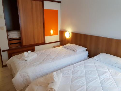 two beds in a hotel room with towels on them at Risthotel Airport in Fogliano Redipúglia