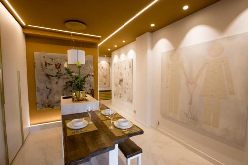 uma sala de jantar com uma mesa e pinturas nas paredes em Boulevard Luxury by Sebastiana Group em San Sebastián