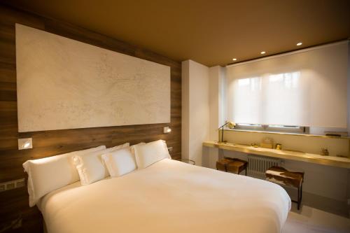 um quarto com uma grande cama branca e uma janela em Boulevard Luxury by Sebastiana Group em San Sebastián
