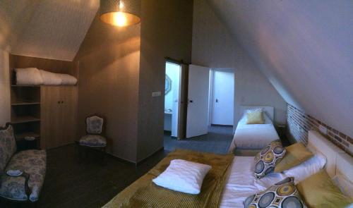 a attic room with two beds and a staircase at Casa della Nonna in Zwalm