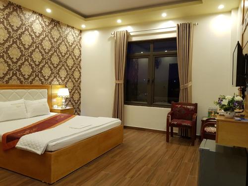 a bedroom with a bed and a window and a chair at Xuan Thanh Hotel in Thanh Hóa