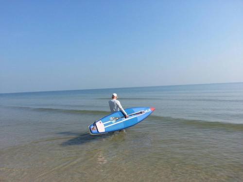 a man sitting on a surfboard in the ocean at Baanchomchan in Hua Hin