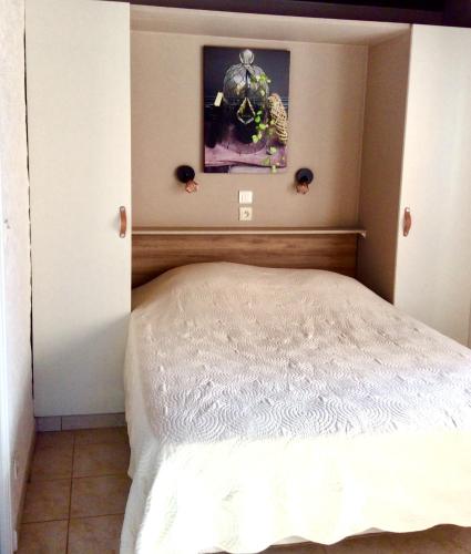a bedroom with a white bed with a picture on the wall at Résidence île de beauté in Propriano