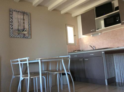 a kitchen with a table and stools in it at Résidence île de beauté in Propriano