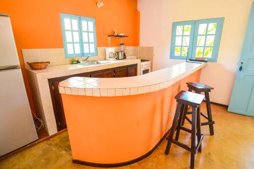 a kitchen with an orange island in the middle at Casa Maya in Santa Catalina