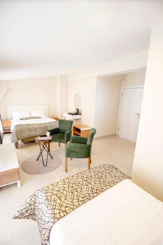 a bedroom with a bed and a couch and a chair at The Corner Inn Hotels By Suit in Eskisehir