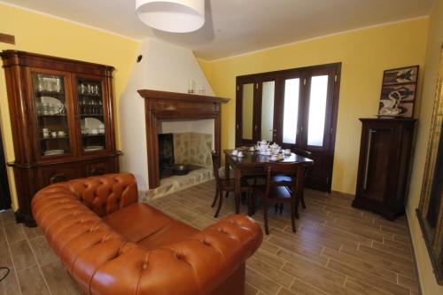 a living room with a leather couch and a table at Villa Brettino- Pesaro mare e cultura - intera struttura con piscina in Fano