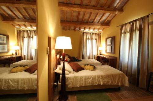 a bedroom with two beds and a floor lamp at Villa Brettino- Pesaro mare e cultura - intera struttura con piscina in Fano