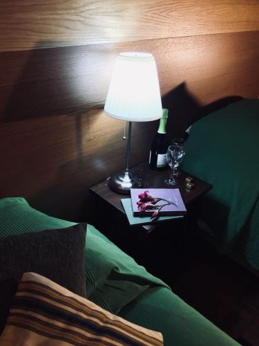 a table with a lamp and a bottle of wine on a bed at Villa Brettino- Pesaro mare e cultura - intera struttura con piscina in Fano