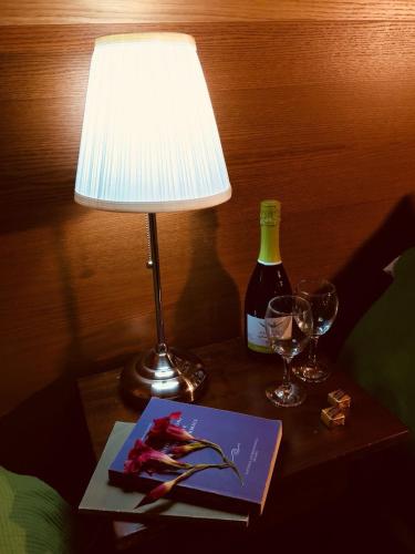 a table with a lamp and a book and a bottle of wine at Villa Brettino- Pesaro mare e cultura - intera struttura con piscina in Fano