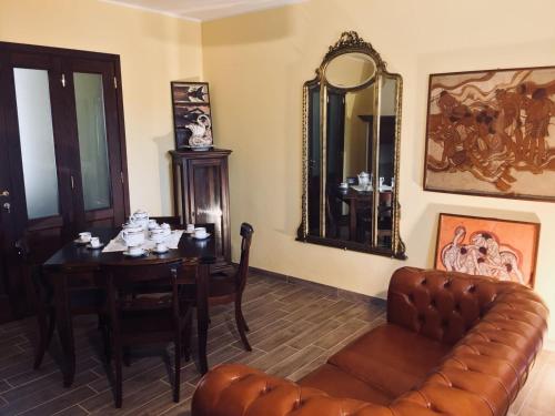 a living room with a table and a couch and a table and chair at Villa Brettino- Pesaro mare e cultura - intera struttura con piscina in Fano