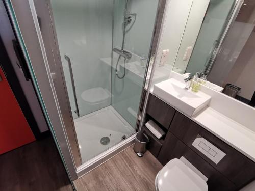 
a bathroom with a shower, sink, and toilet at easyHotel Sheffield in Sheffield
