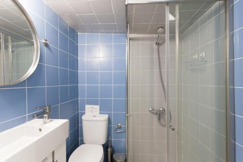 ein Bad mit einem WC und einer Dusche mit blauen Fliesen in der Unterkunft FLH Alfama Cozy Apartment in Lissabon