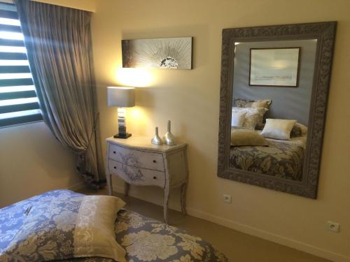 une chambre avec un miroir et un lit dans l'établissement Residence de Croisset Vue panoramique Cote d Azur, à Grasse