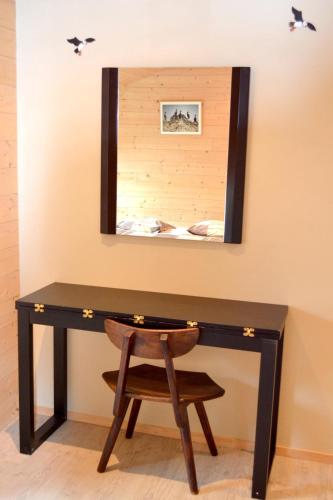 a desk with a chair in front of a mirror at Chambres d'Hôtes Le Nid d'Iroise in Lanildut