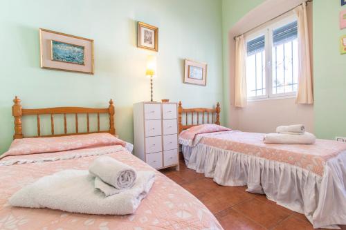 a bedroom with two beds with towels on them at Vive la campiña Sevillana - Terraza y 3 Hab in El Viso del Alcor