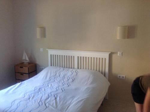 a bedroom with a white bed and a night stand at Casa Pauline in Benissa