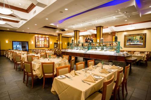 a restaurant with white tables and chairs and a bar at The Belvedere Hotel in New York