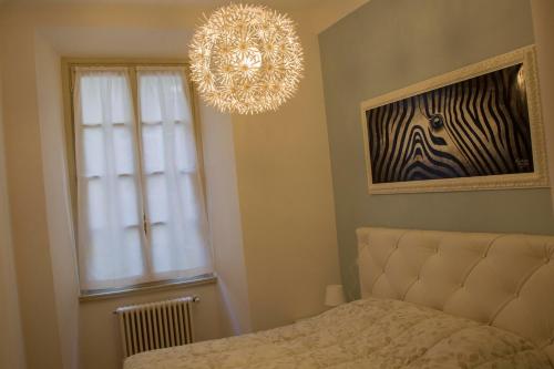 una camera con letto, lampadario a braccio e finestra di Lella's Home a Como