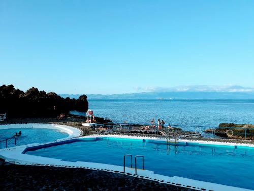 duas piscinas com o oceano ao fundo em Casa Amaral em Santo Antônio