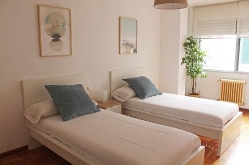 ビラガルシーア・デ・アロウサにあるApartamento Vilagarcía de Arousaの窓付きの客室で、ベッド2台が備わります。