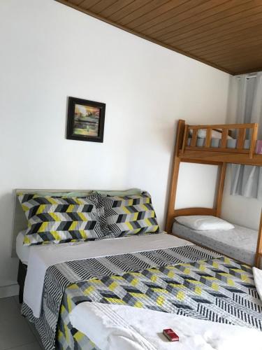 a bedroom with two beds and a bunk bed at Chalé Temporada Porto dos Lençóis - Lençóis Maranhenses in Barreirinhas