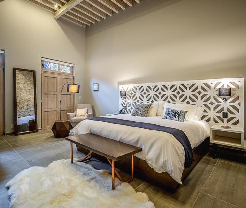 a bedroom with a large bed and a table at Hotel Casa Once in Querétaro