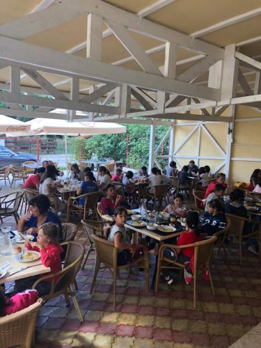 eine Gruppe von Kindern, die in einem Restaurant an Tischen sitzen in der Unterkunft Mario Residence in Costinești