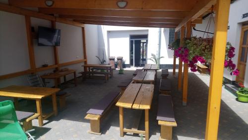 a row of wooden tables and benches in a building at Penzion Klimeš in Hustopeče