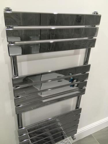 a metal rack on a wall with metal pans at Woodlands Holiday Apartments in Lytham St Annes