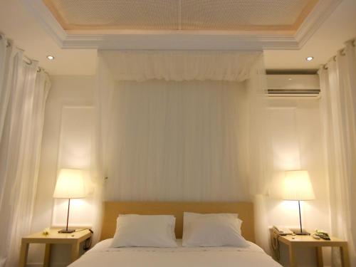 a bedroom with a bed with two lamps on two tables at São Gonçalo - Alojamento in Azeitao
