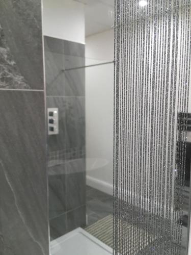 a shower with a glass door in a bathroom at Woodlands Holiday Apartments in Lytham St Annes