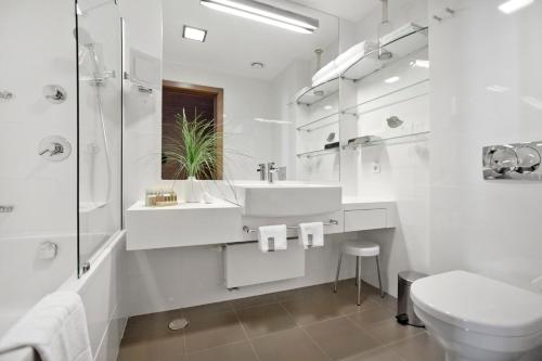 a white bathroom with a sink and a toilet at Hotel Croatia in Cavtat