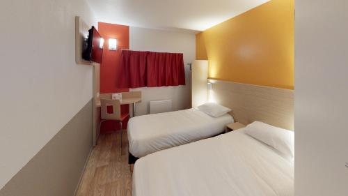 a hotel room with two beds and a red window at Première Classe Reims Ouest - Tinqueux in Reims