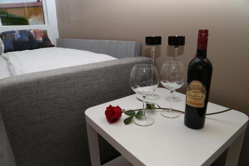 a bottle of wine and two wine glasses on a table at Country Dream - Langholt 2 in Selfoss
