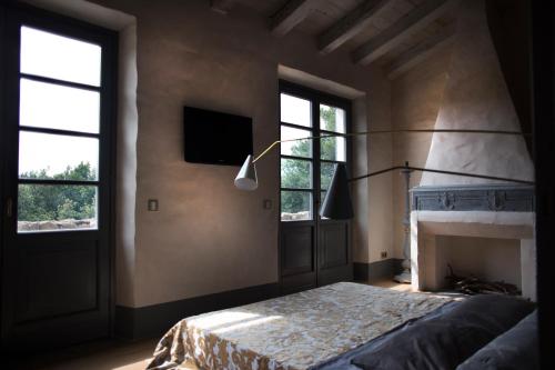 1 Schlafzimmer mit einem Bett, einem TV und 2 Fenstern in der Unterkunft B&B La Fustaia in Sarzana