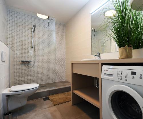 a bathroom with a toilet sink and a washing machine at Modern & Comfy Sea View House NG in Portorož