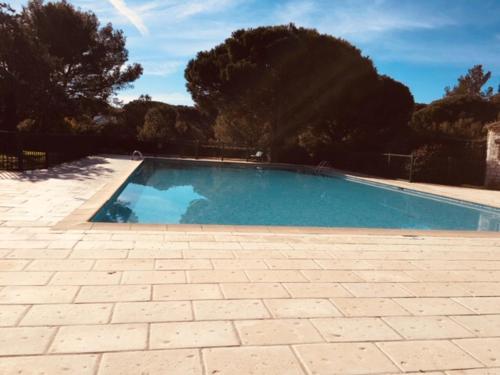 une piscine dans une cour avec des arbres en arrière-plan dans l'établissement Maison Joge, à Gassin