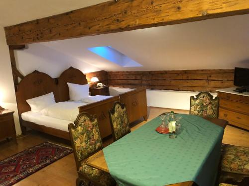 Schlafzimmer mit einem Bett, einem Tisch und Stühlen in der Unterkunft Posthotel Sachrang in Sachrang