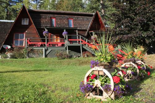 a house with flowers in front of it at Sunny Bluffs Chalets in Kaslo